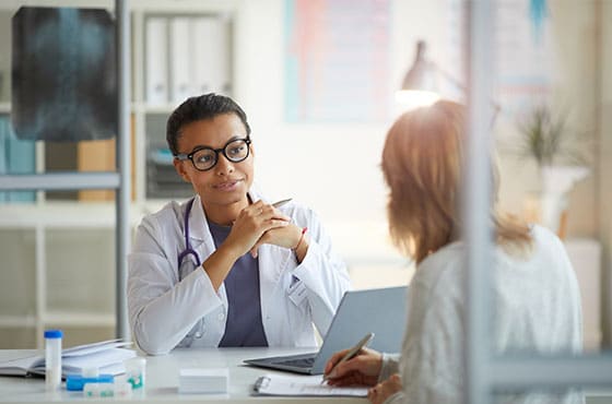 A doctor talks through paperwork with her patient