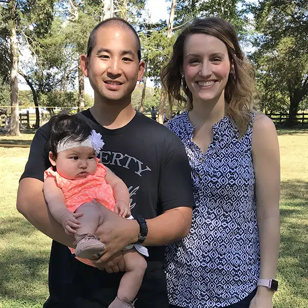 Hannah and John hold their baby outside